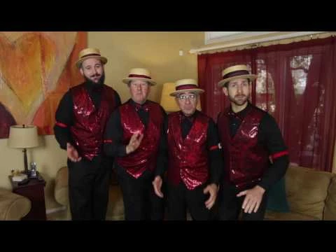 Four quartet singers in red vests and straw hats, from the singing Valentines advertisement.